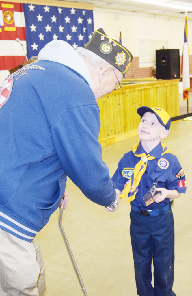 Cub Scout David Rose shakes hands with Jerry Coley, a Korean War veteran during Saturday’s 70th anniversary open house at the Bowie Veterans of Foreign Wars Post No. 8789. The scouts opened the program with the posting of colors and the pledge of allegiance. 